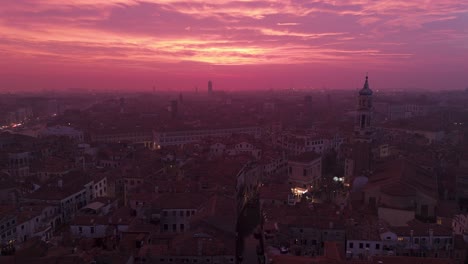 Venecia-Al-Atardecer-Con-Cielo-Rosado-Y-Luces-De-La-Ciudad-Comenzando-A-Brillar,-Vista-Aérea