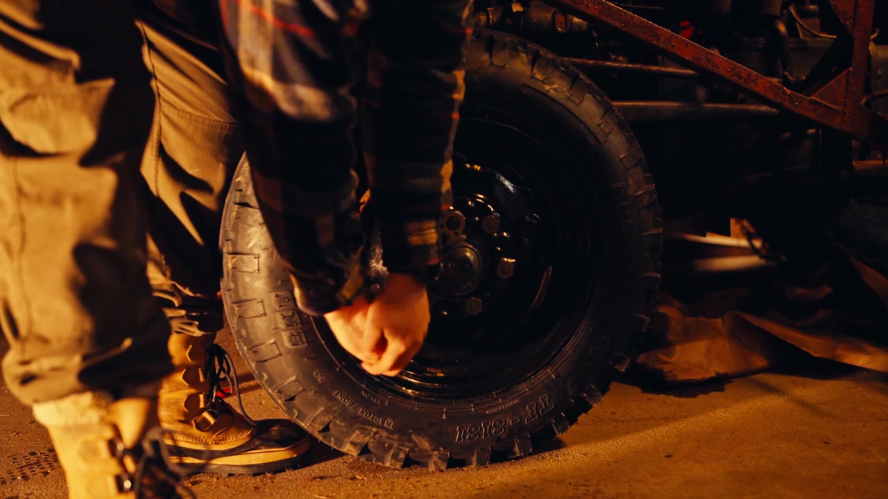 Person Using A Lug Wrench To Tighten The Lug Nuts On A Car Wheel. Close-up Shot