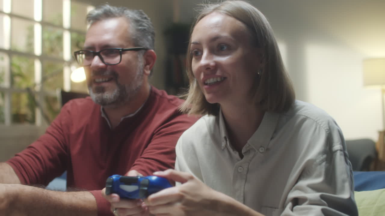Couple playing video games together at home