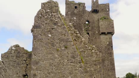 Srah-Castle-siding-with-grass-growing-between-bricks-of-old-wall,-aerial