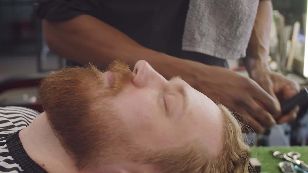 barbero peinando y recortando el bigote del hombre