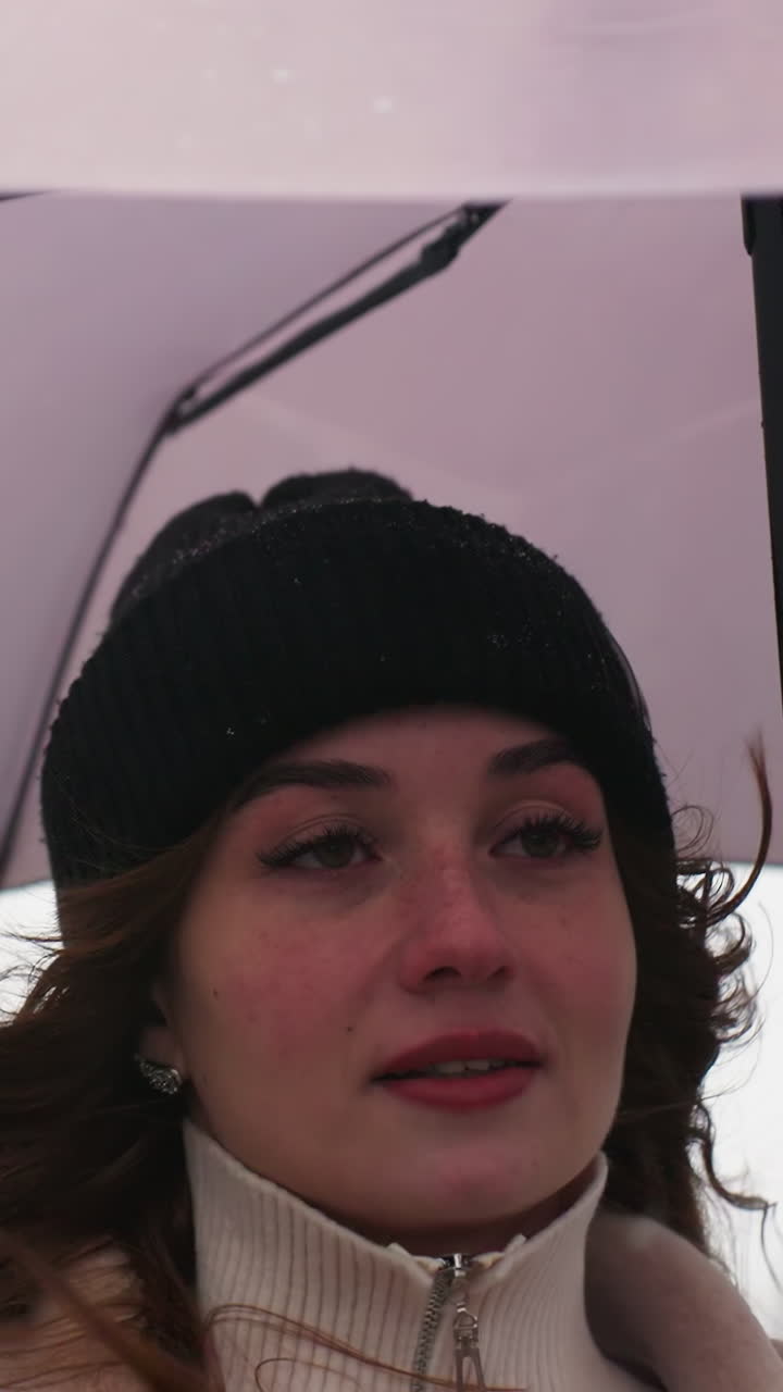 Close shot of thoughtful girl running in light snowfall holding umbrella wearing knit cap brown shearling jacket, cold weather, serene atmosphere, winter scene, casual outdoor style, snowy day