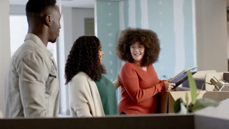 casual diverse businesspeople carrying boxes moving into office, slow motion with copy space