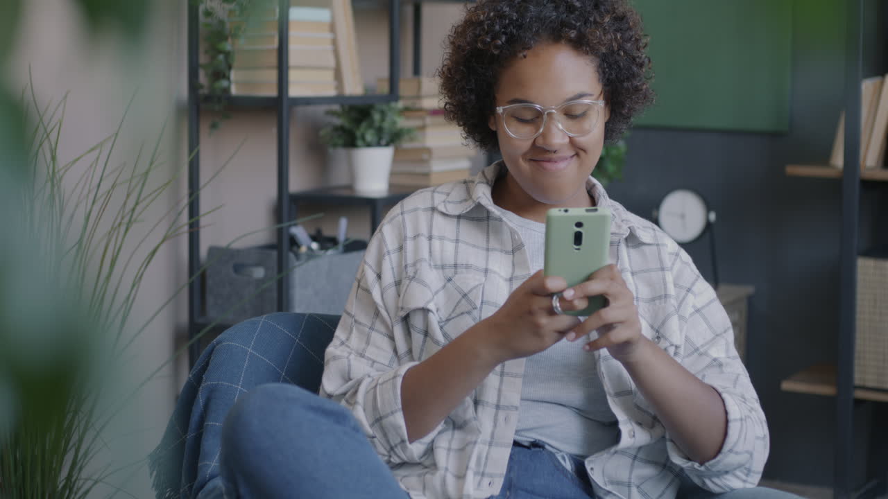 Woman using smartphone in a comfortable living room setting