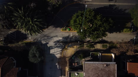 encrucijada en una calle tranquila con casas privadas, trópicos, verano, palmeras, el dron vuela hacia abajo