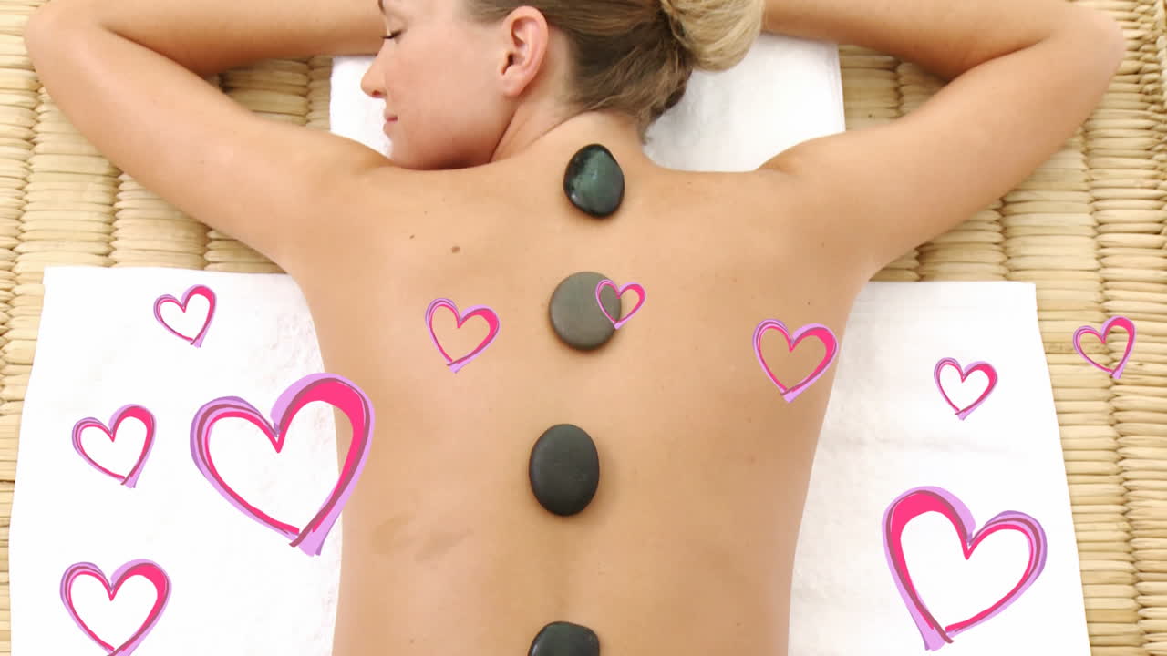 아름다운 금발 여성들이 발렌타인 데이에 분홍색 마음으로 스파에서 누워서 휴식을 취하고 있습니다.