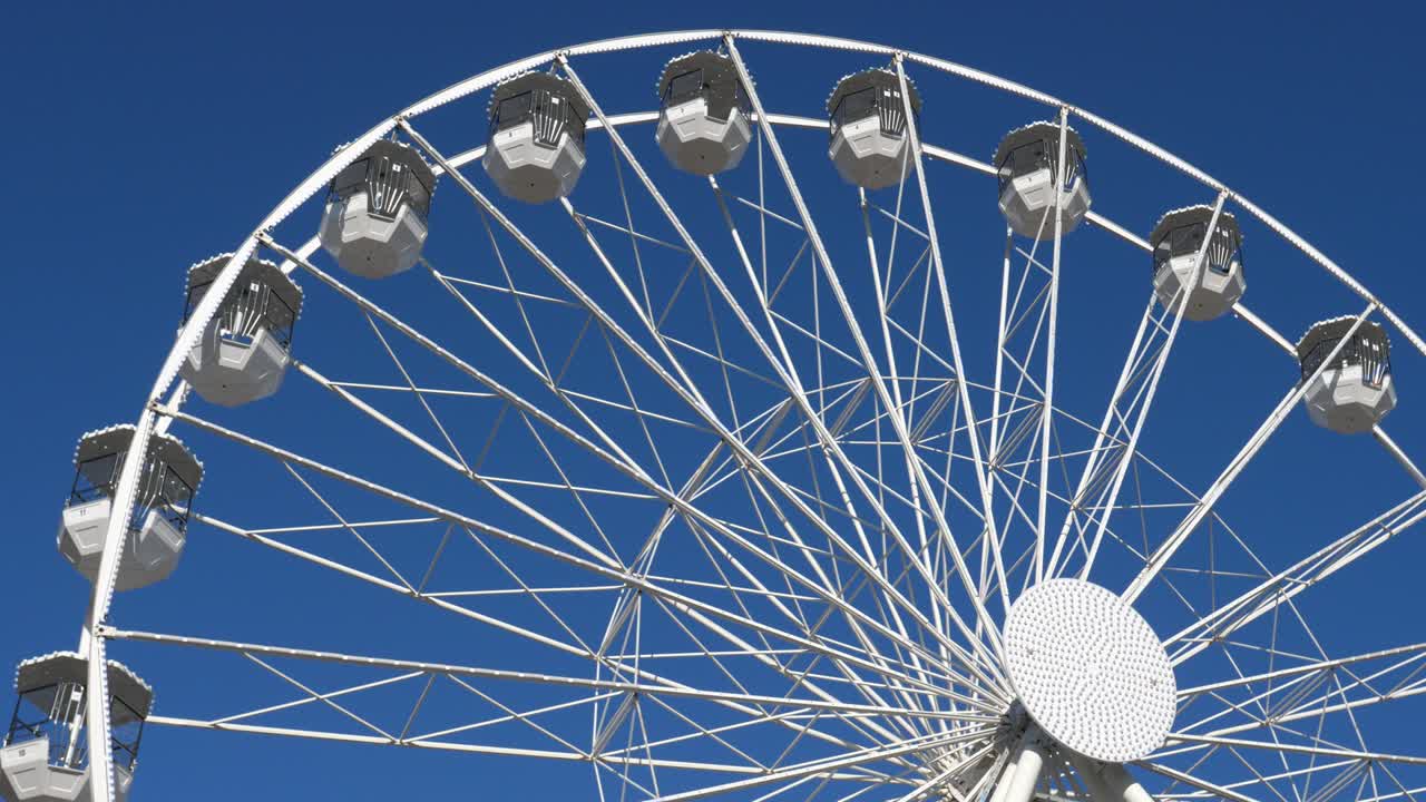 la rueda gigante en acción contra un cielo azul.