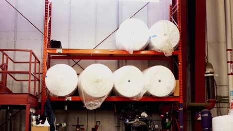 Six-Massive-Rolls-of-Industrial-Engineering-Protective-Shipping-Plastic-Wrap-Stick-Water-Proof-Film-on-a-Distribution-Center-Metal-Rack-inside-a-Warehouse