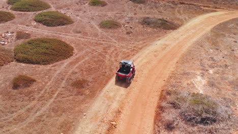 toma de seguimiento siguiendo a un vehículo de cuatro ruedas corriendo por caminos de tierra en el desierto.