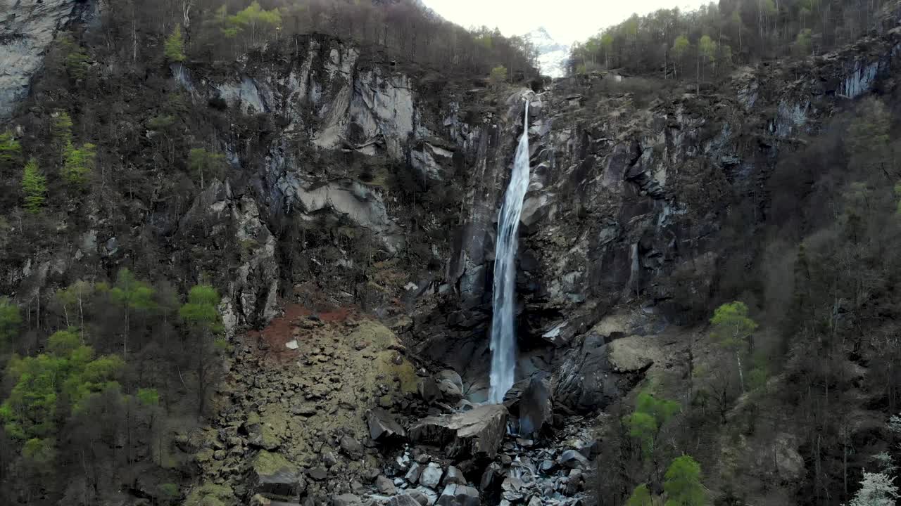 sobrevuelo aéreo sobre foroglio en ticino, suiza, con un movimiento panorámico desde la cascada hasta los tejados de las antiguas casas de piedra del pueblo