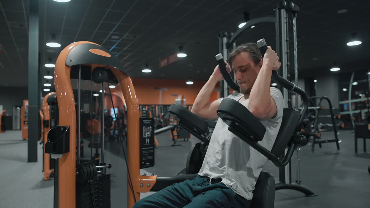 Premium stock video - 20s male working out abs with crunch machine in ...