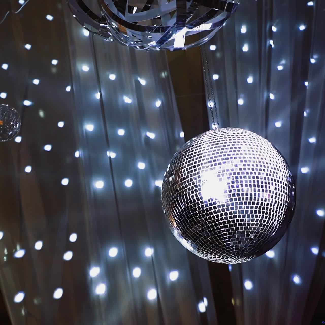 Nightclub ceiling with many shining balls. Disco ball shimmering and spinning on the glittering background.