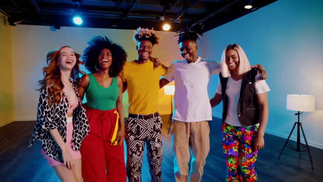 diverse group of friends dancing and having fun in a colorful studio