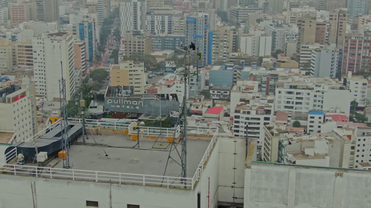 Black Vultures Perched on High-Rise Tower With Spiral Drone Orbit — Lima Coastline to Urban Skyline