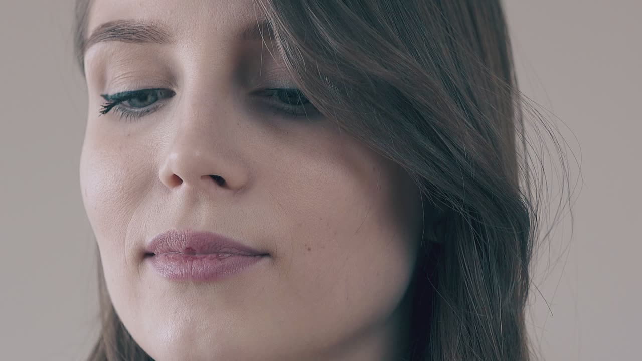 hermosa mujer joven con maquillaje diario sobre un fondo gris