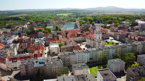 prudnik's historic center, featuring the prominent church, town hall, and scenic surrounding countryside