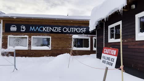 mt mackenzie outpost with falling snow hanging icicles and caution falling snow sign in foreground at revelstoke british columbia canada