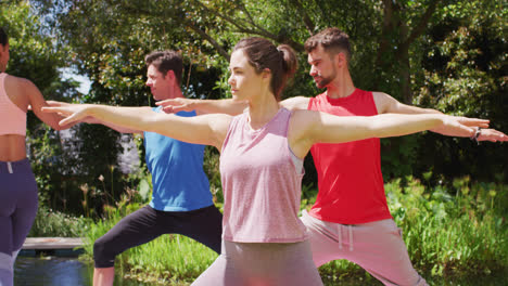 diverse group practicing yoga pose in sunny park with asian female instructor helping