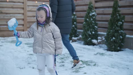 grandfather and granddaughter having fun in the snow