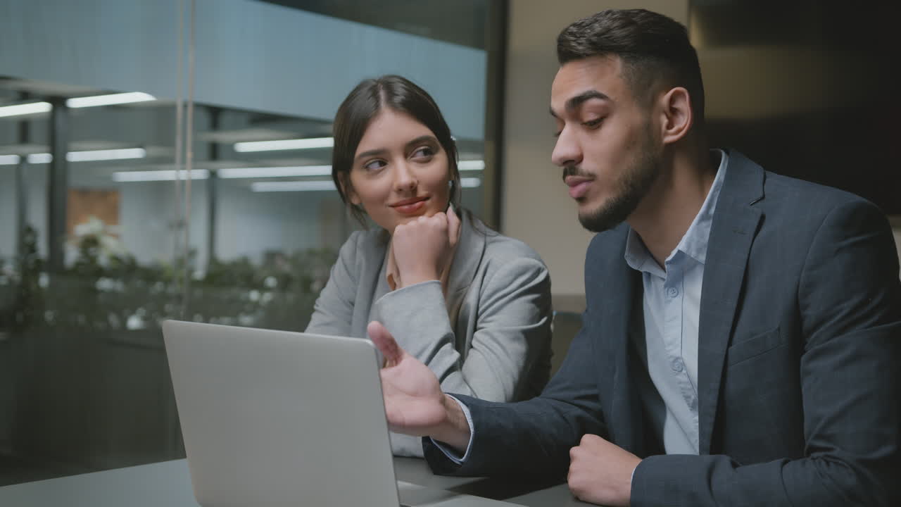 Business Professionals Discussing Work on Laptop in Office