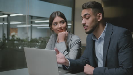 business professionals discussing work on laptop in office
