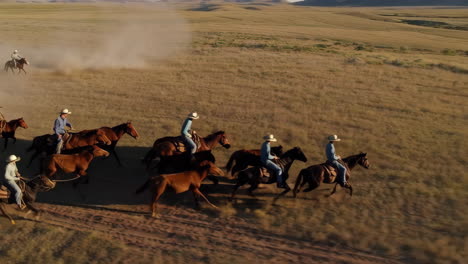 cowboys riding horses in the prairie