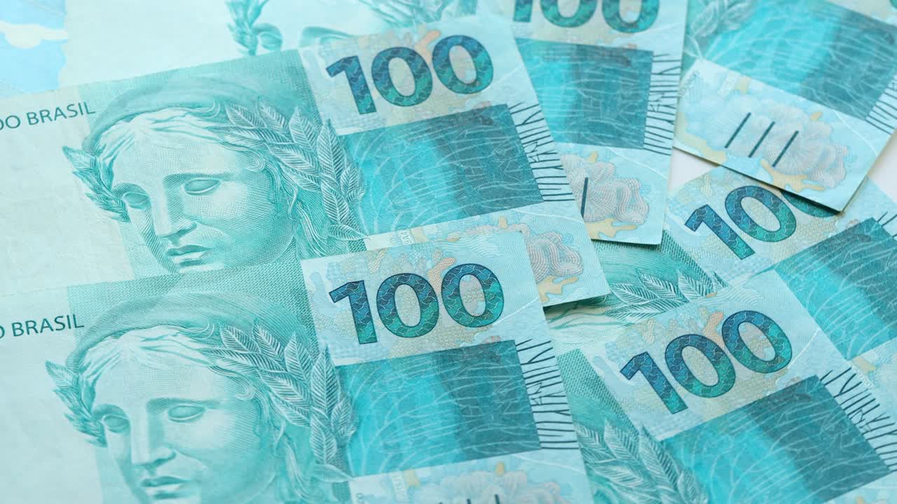 moneda brasileña. mucho dinero, billetes de 100 reais girando lentamente sobre su propio eje