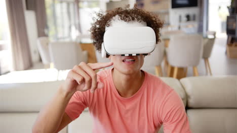 Un-Joven-Birracial-Está-Usando-Auriculares-Vr-En-El-Sofá-De-Casa,-Fondo-Blanco