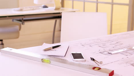 architects desk with stationery and blueprint