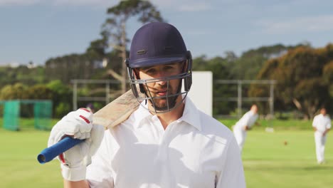 cricket player with helmet and bat looking at the camera