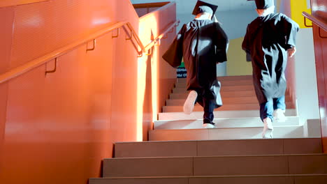 primer plano de dos estudiantes de jardín de infantes subiendo las escaleras en la ceremonia de graduación de preescolar