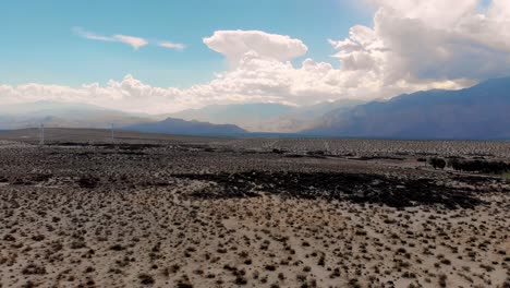 Slow-push-in-over-desert-brush-and-windmills-drone-near-Palm-Springs,-CA