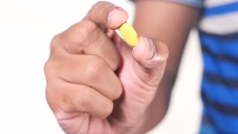 person holding a yellow pill