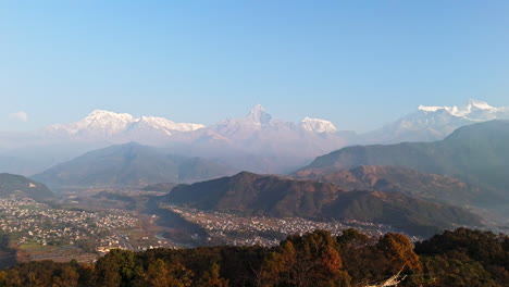 aerial: pokhara city and snow covered, himalayan peaks in nepal, sunny morning