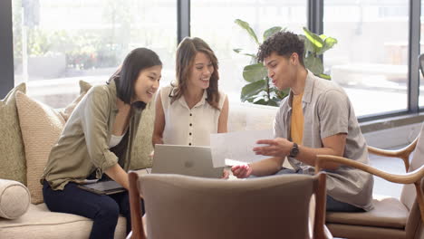 collaborating on interior design project, multiracial team reviewing plans with laptop, at office