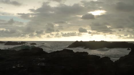 a storm blows in over the ocean at sunset