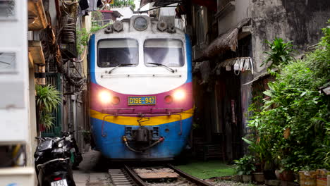 train passing through a narrow city street in vietnam