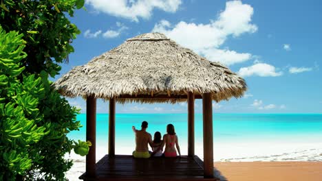 caucasian family outdoors in a tropical beach hut