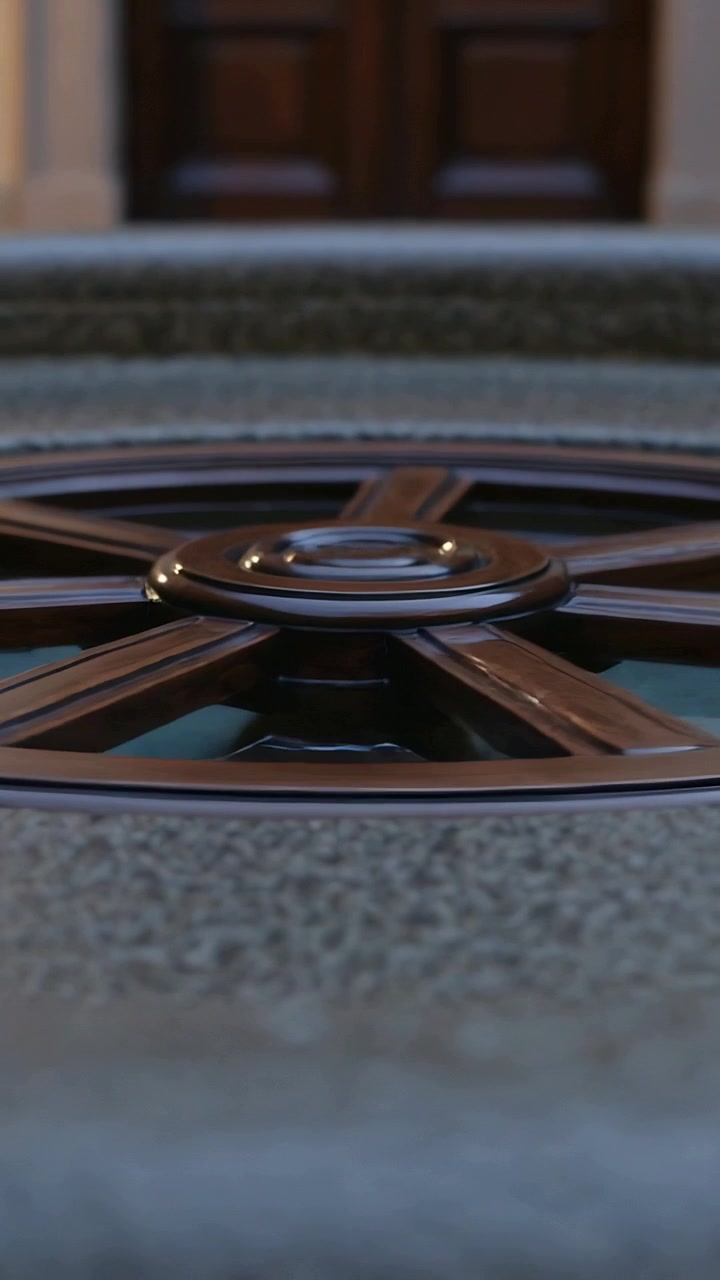 Vertical video: Pulling back lens revealing wagonwheel metal grate on stone step