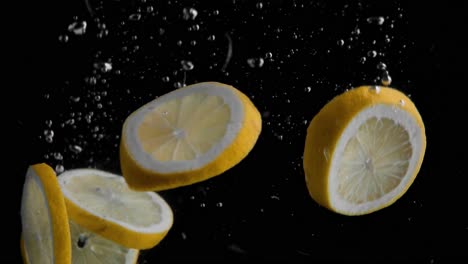 lemon slices falling into water super slowmotion, black background, lots of air bubbles, 4k240fps