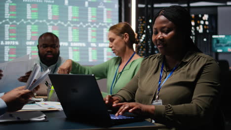 african american analyst and colleagues examining annual data reporting