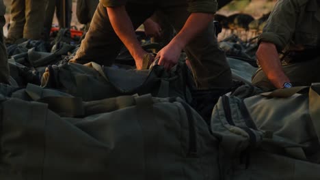 close-up of soldiers hands and military bags with combat gear as soldiers prepare for fighting