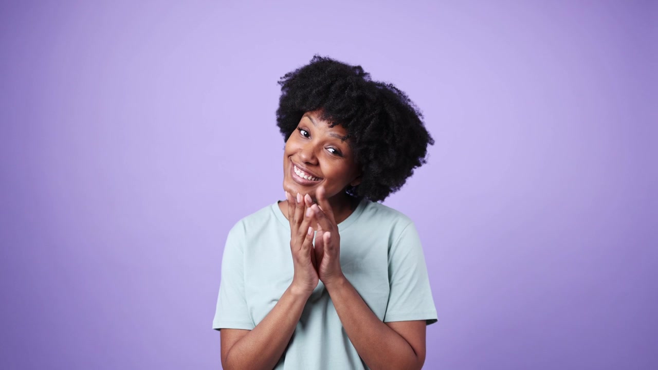 Young African American Woman Pleading with Hands Together and Smiling