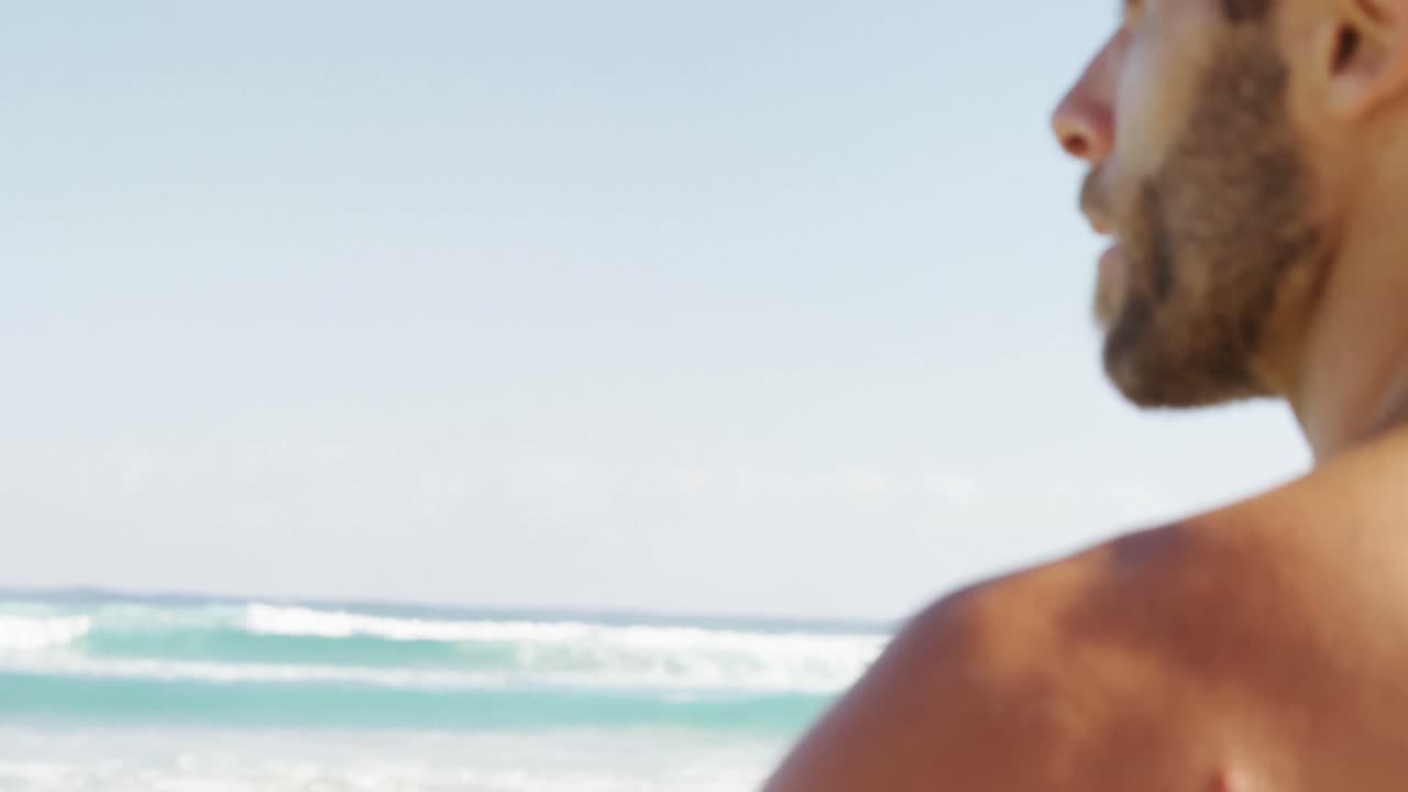 Surfista uomo in piedi sulla spiaggia