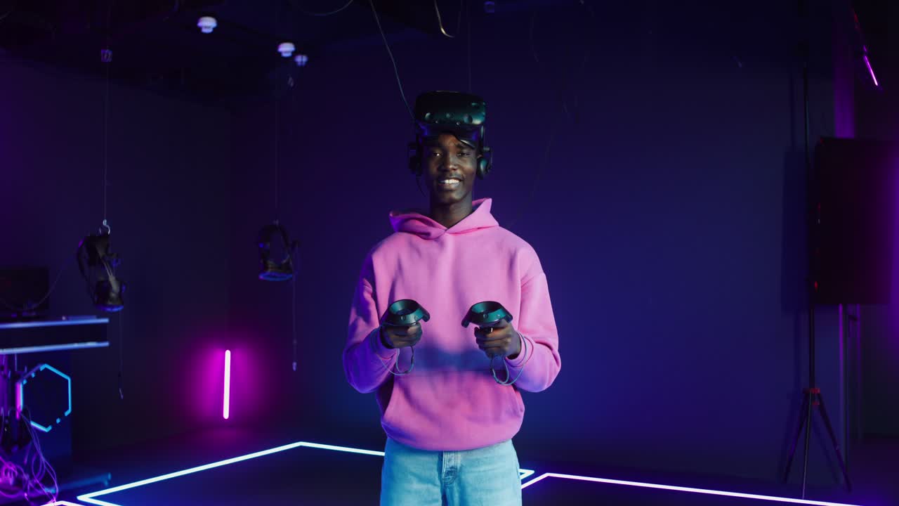 A man using virtual reality headset in a gaming studio with neon lights