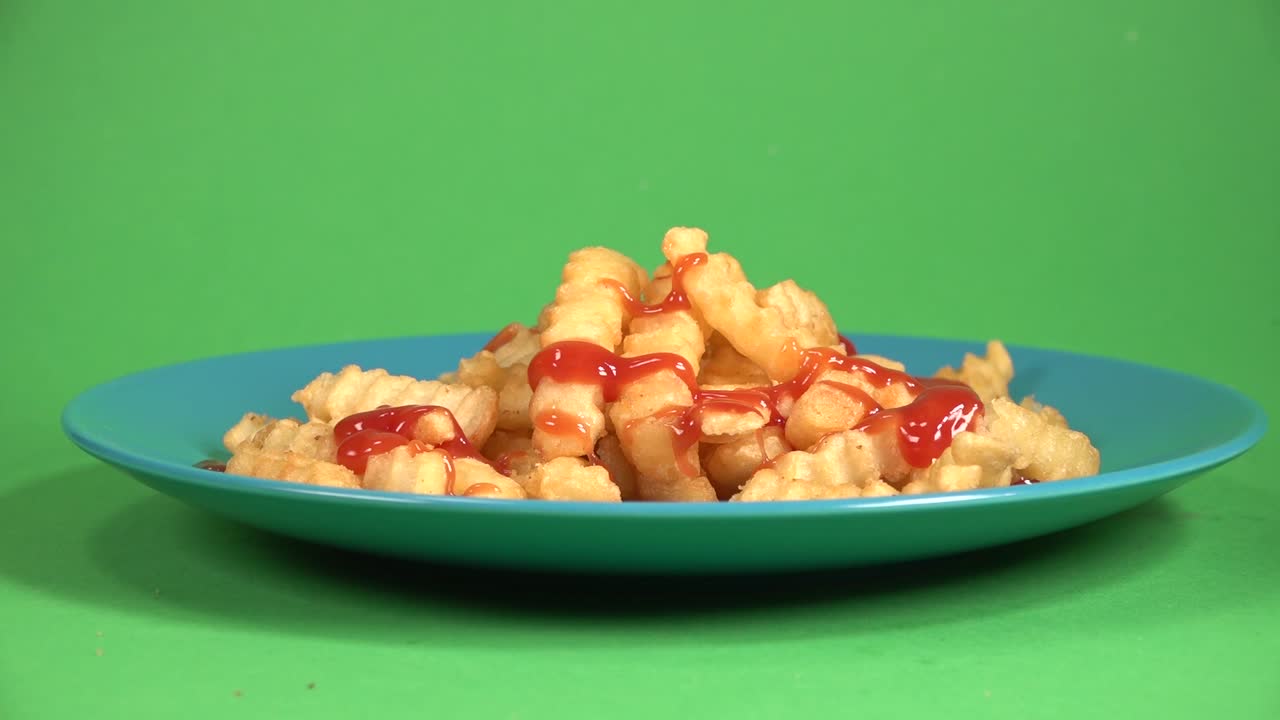 ketchup vertido sobre patatas fritas sobre un fondo cromático