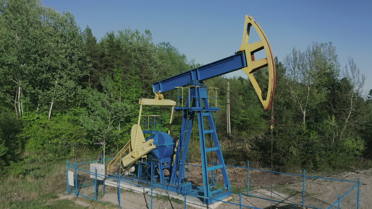 Zoom aereo all'indietro da un pumpjack che estrae petrolio greggio vicino a Campina, Romania.