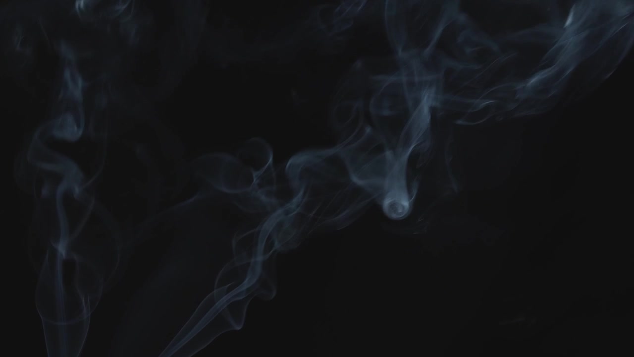 Sottile strato di fumo che si diffonde verso il cielo su sfondo nero