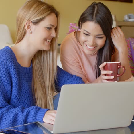 two happy young women browsing the internet