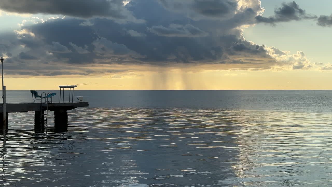 Rain storm clouds in distance off boat dock, Florida. Keys ocean